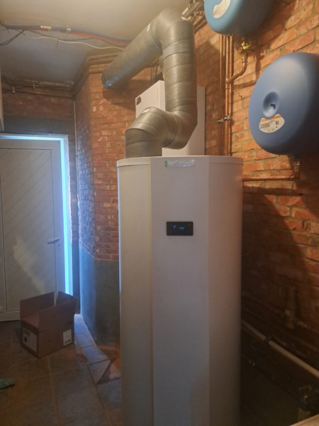 Warmtepompboiler van 298 liter in een berging met bakstenen muur in Kapellen